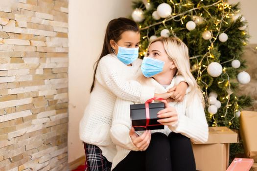 People with gifts wearing facemasks during coronavirus and flu outbreak on Christmas. Virus and illness protection, home quarantine. COVID-2019.