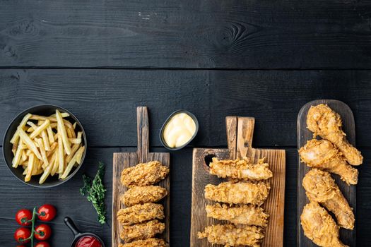 Crispy kentucky fried chicken cuts on black wooden background, flat lay, with space for text.