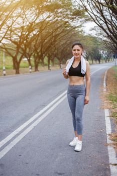 young sporty woman with white towel resting after workout sport exercises outdoors at the park