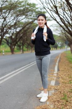 young sporty woman with white towel resting after workout sport exercises outdoors at the park