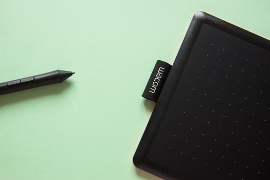 Tver, Russia - February 3, 2020 Top view of Wacom graphic tablet on pastel green background. Space for text. Selective focus.