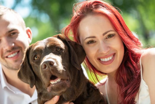 A couple and their dog in the park. Spending time with friends