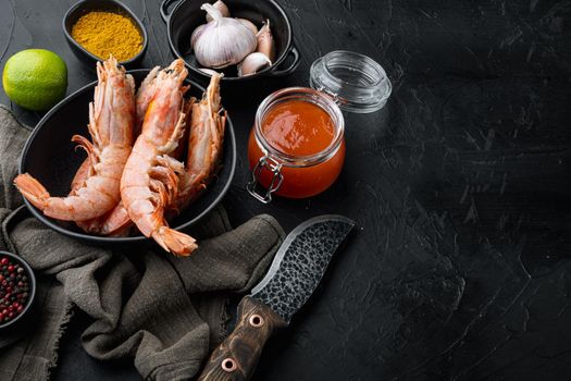Mango chutney Large raw shell on raw king prawns ingredients set in bowl, on black background , with copyspace and space for text