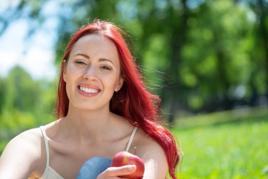 Portrait of a young attractive woman in the park. Smiling and happy