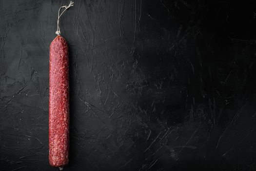 Sausage paperoni Salami with paprika set, on black dark stone background, top view flat lay, with copy space for text