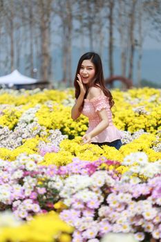 beautiful woman in colorful chrysanthemum glower garden 