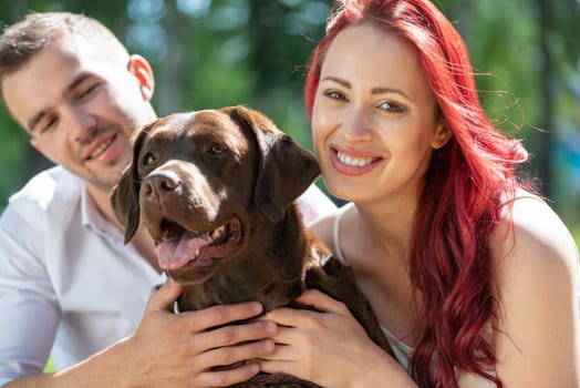 A couple and their dog in the park. Spending time with friends