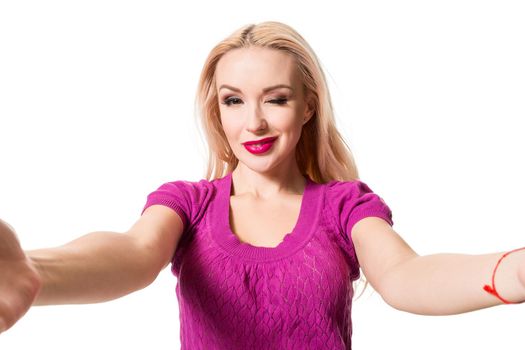 Smiling cheerful blond-haired woman doing selfie on isolated white background. Taking picture.