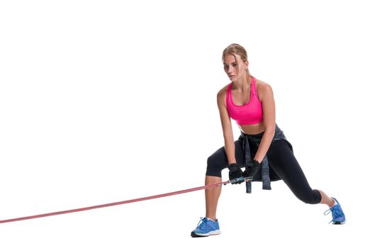 Strong woman using a resistance band in her exercise routine. Young woman performs fitness exercises on white background. Woman with beautiful slim healthy body posing in studio.