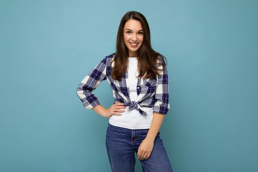 Portrait of positive cheerful fashionable woman in hipster outfit isolated on blue background with copy space.