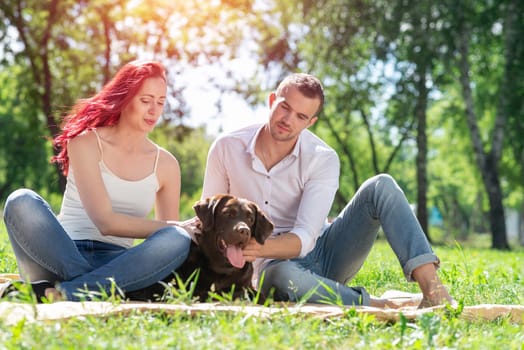 A couple and their dog in the park. Spending time with friends