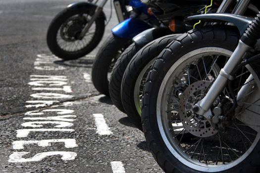 The front wheels of motorcycles parked in a bay