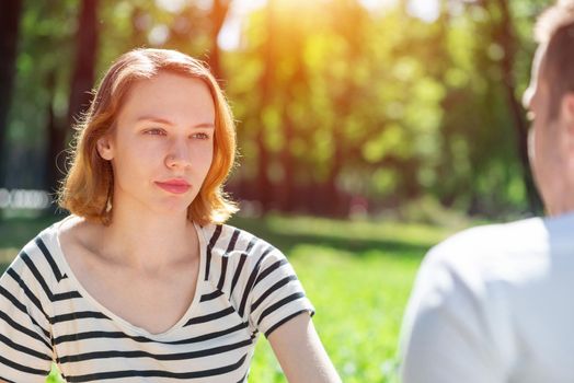 Portrait of a young attractive woman on a date in a park. Spending time with loved ones
