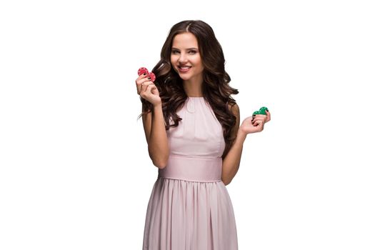 Sexy woman in a chic gently pink dress holding colored poker chips. Isolated on white background. Woman winning. Casino. Poker. Victory. Luck Roulette Blackjack Spin. Big win emotions