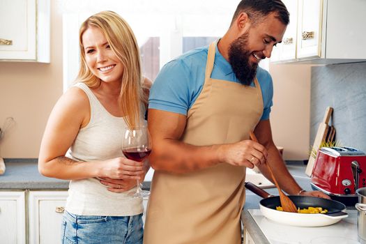 Couple in love preparing meal together in kitchen at home