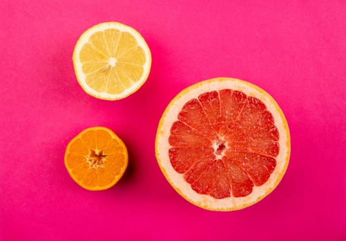 Citrus fruits slices isolated on pink background