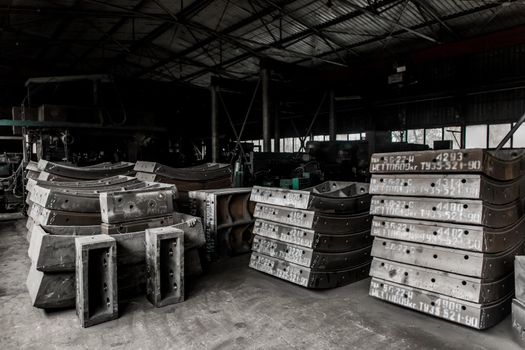 Cast iron tubing reinforced concrete cast products for lining distillation tunnels and underground structures are stored in the warehouse of the industrial plant.