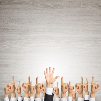 Group of hands of businesspeople showing gestures on wooden background