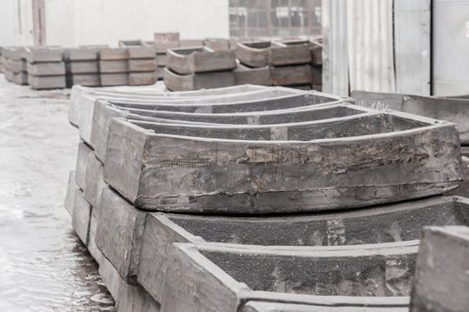 Cast iron tubing reinforced concrete cast products for lining distillation tunnels and underground structures are stored in the warehouse of the industrial plant.