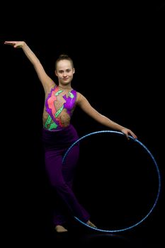 A girl gymnast performs an exercise with a hoop. The concept of gymnastics and fitness. Isolated.