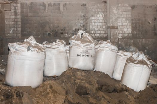 Bentonite clay powder packed in bags at an industrial plant for processing sand, soil and land.