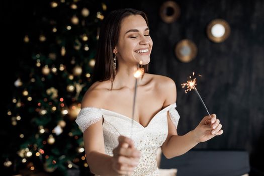 Young woman with sparklers and champagne. New Year covid, woman in dress in mask. High quality photo