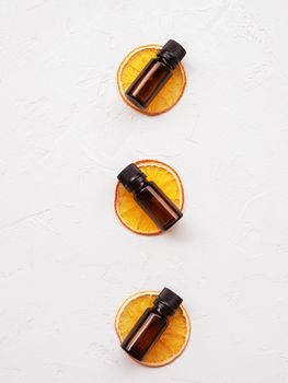 Beauty natural product. Useful aromatherapy, aromatic baths, alternative medicine, vitamins. Bottles of citrus essential oil on slices of dried orange composition on a white background.