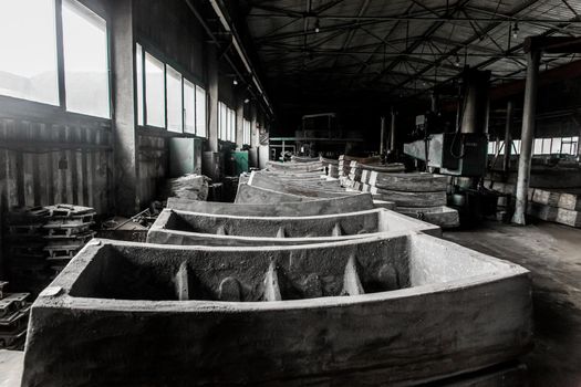 Cast iron tubing reinforced concrete cast products for lining distillation tunnels and underground structures are stored in the warehouse of the industrial plant.