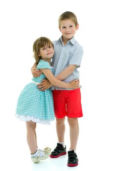 Charming little girl hugging a tall boy with blond hair. A romantic couple is happy with the joint time brought. A happy sister hugs her brother. The concept is a happy childhood. Isolated on white background.