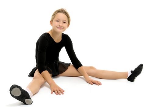 A sweet little gymnast girl performs an acrobatic element on the floor. The concept of sport, healthy lifestyle. Isolated on white background.