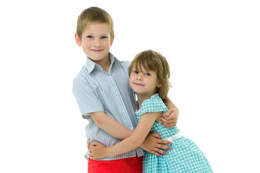 Charming little girl hugging a tall boy with blond hair. A romantic couple is happy with the joint time brought. A happy sister hugs her brother. The concept is a happy childhood. Isolated on white background.
