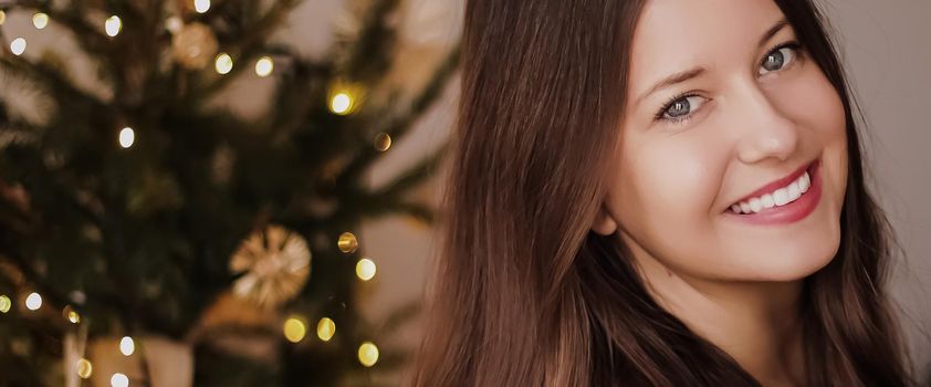 Christmas time and holiday mood concept. Happy smiling woman and decorated xmas tree lights on background.