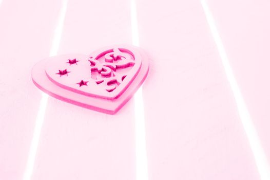 Pink heart on a white wood background - love and valentines day concept. Toned. Copy space.