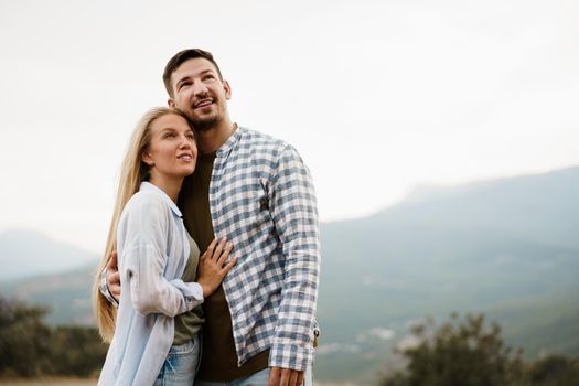 Happy loving couple hiking and hugging in mountains, close up