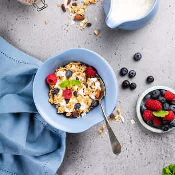 Homemade oatmeal granola or muesli with yogurt and fresh berries for healthy morning breakfast, selective focus. Healthy food background.