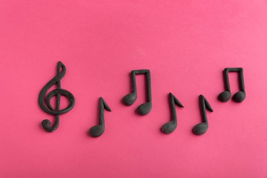 Treble clef and music notes on pink background. Music symbol. Key of G. Violin key. Musical notation