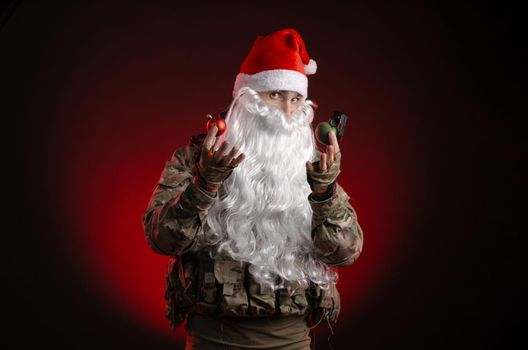 the man in a military uniform with a gun and a Santa Claus hat