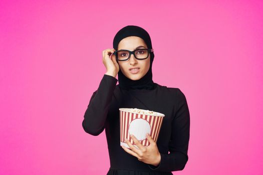 Muslim woman entertainment cinema popcorn fashion purple background. High quality photo
