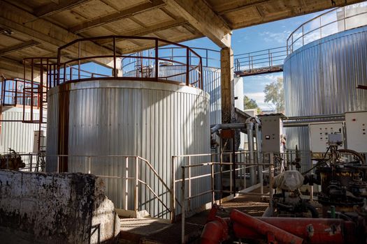 Section of manufacturing production plant with pipes and industrial metal containers