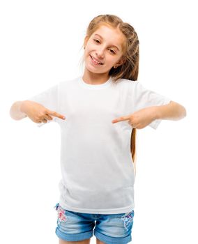 Positive little girl in casual white T-shirt indicates at blank space for logo design