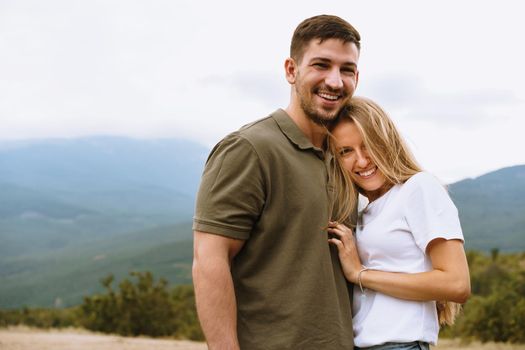 Happy loving couple hiking and hugging in mountains, close up