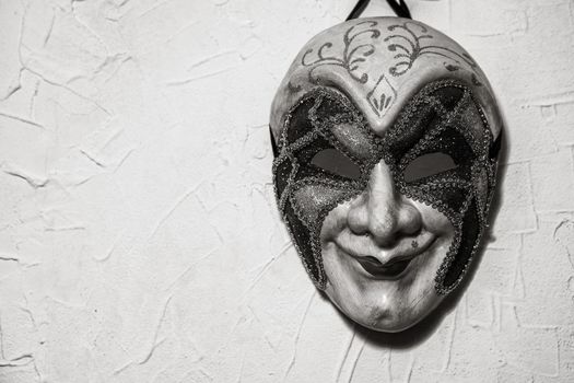 Sinister Joker mask on white wall