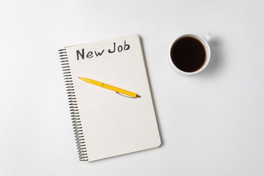 Notepad, pen and coffee cup on white background. A new job. Ideas, plans and strategy. Top view.