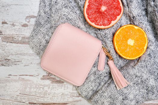 Little pink female purse, and citrus on a sweater. Fashionable concept.