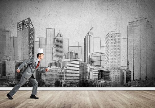 Young handsome businessman wearing white paper crown running in a hurry