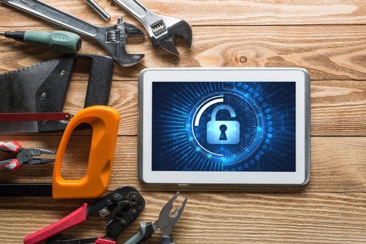 Tablet pc with security concept on screen and industrial tools around
