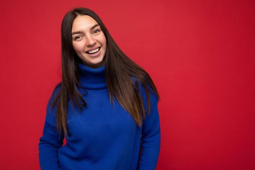 Photo of beautiful positive smiling adult woman wearing stylish clothes standing isolated on colorful background with copy space looking at camera.