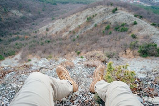 Man resting in the mountains, view of legs. Point of view shot