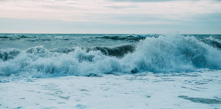 Beautiful sea waves with foam and blue sky, front view