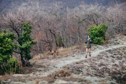 Hiker young woman walking on path outdoor. Concept minimal person in massive landscape